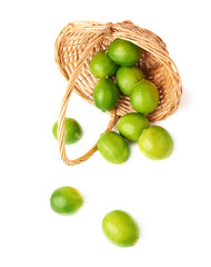Wicker basket full of multiple ripe limes, composition isolated