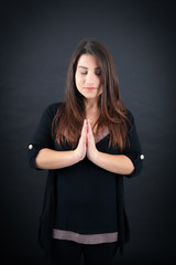 Beautiful woman doing different expressions in different sets of clothes: prayer