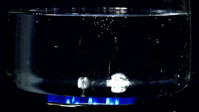Boiling water in glass pan on gas flame