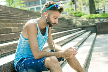 Man listening to the music with earbuds from a smart phone 
