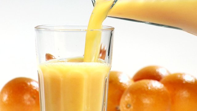 Pouring orange juice from a jug into a glass