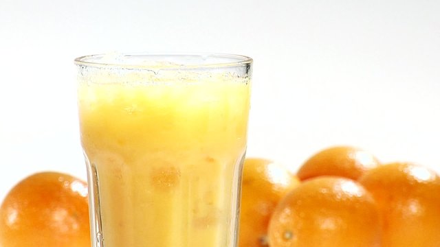 Pouring orange juice into a glass of crushed ice