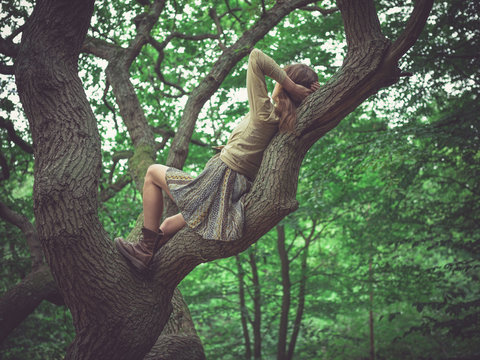 Young woman lying in a tree