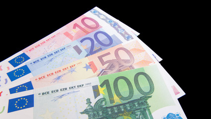 Various euro notes on black background