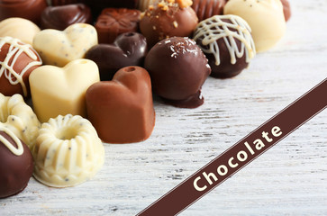 Delicious chocolate candies on wooden background