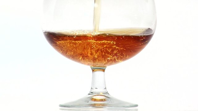 Pouring a glass of cognac (close-up)