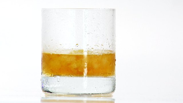 Pouring whisky into a glass of crushed ice