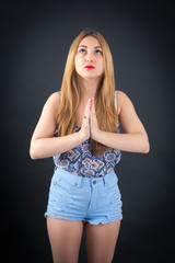 Beautiful girl doing different expressions in different sets of clothes: prayer