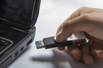 Hand inserting usb memory stick to laptop computer