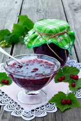Red currant jam on a wooden background