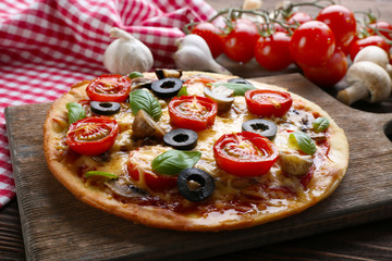 Tasty pizza with vegetables and basil on table close up