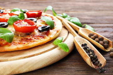 Tasty pizza with vegetables and basil on table close up