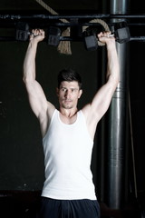Naklejka premium very power athletic guy , execute exercise with dumbbells, on bkack background