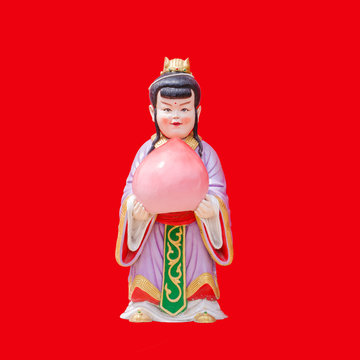 Sculpture China Doll Holging A Peach On Red Background