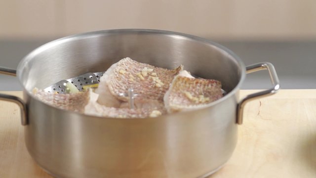 Steamed fish fillets in a saucepan