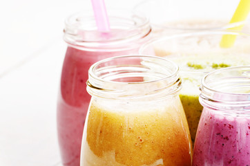 Assorted fruit and vegetable shakes on white table