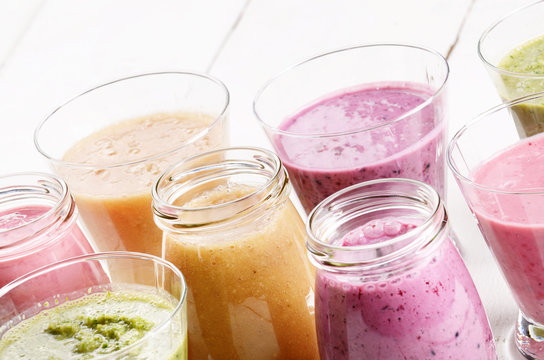 Assorted fruit and vegetable shakes on white table