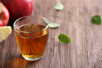 Glass of apple juice and fruits on table close up