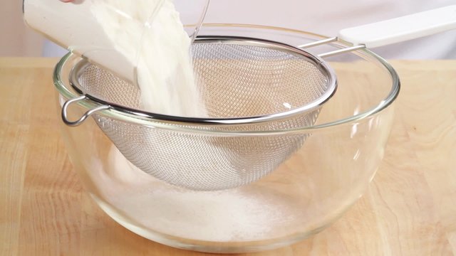 Flour being sieved into a bowl