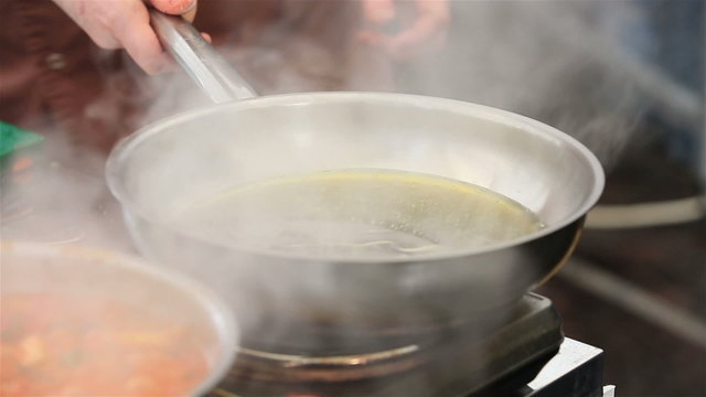 Chef heats up the sunflower oil in a pan.