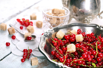 Fresh red currants with sugar on table close up