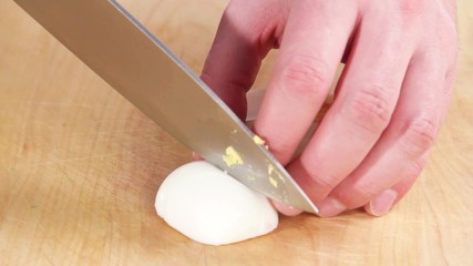 A hard boiled egg being chopped - Powered by Adobe