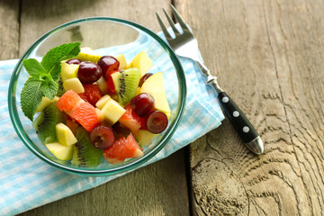Fruit salad in glass bowl, on  wooden background