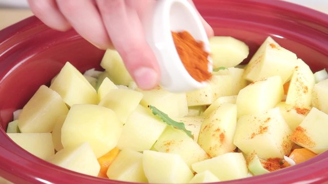 Potato stew being seasoned