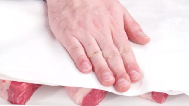 New York strip steaks being patted dry