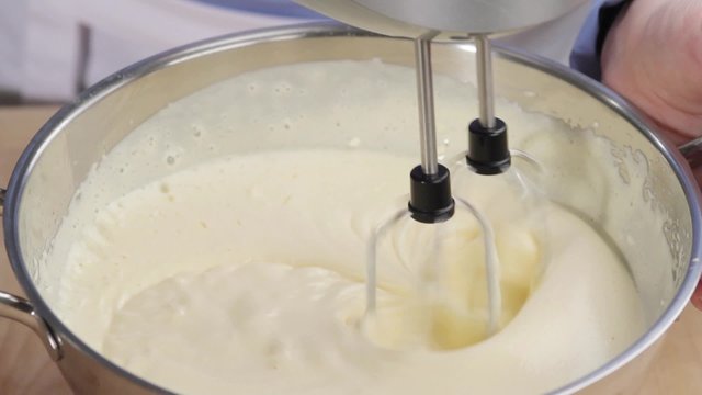 Butter cream being stirred with a hand mixer