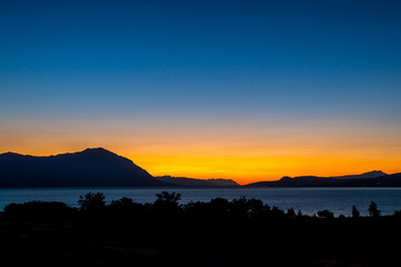 Colorful evening blue hour sunset over the mountains and a lake
