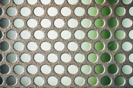Metal plate with many small circular holes, macro texture backgr