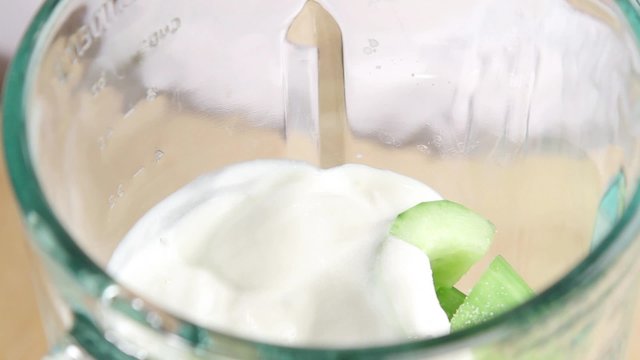 Yogurt and cucumber being seasoned in a blender