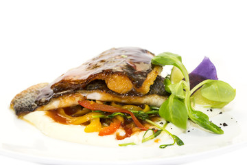 baked fish with vegetables and mushrooms in a restaurant