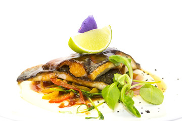 baked fish with vegetables and mushrooms in a restaurant