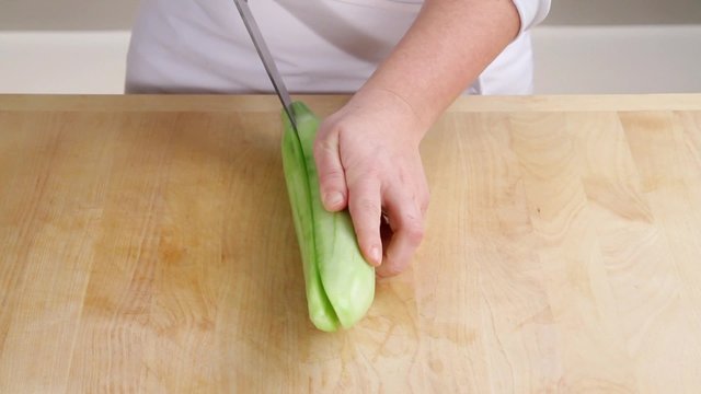 A cucumber being halved lengthways