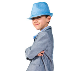 Child with his arms crossed wearing a blue hat