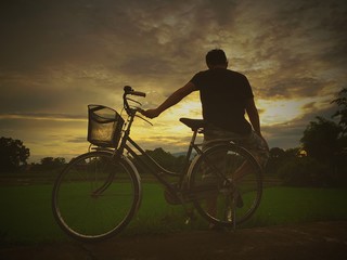 man resting on bicycle