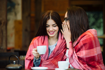 Two young and beautiful girls gossiping