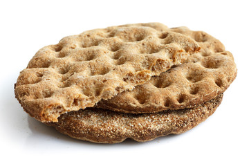 Stack of three round rye crispbreads isolated on white. One brok
