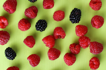 raspberries and blackberries light green background