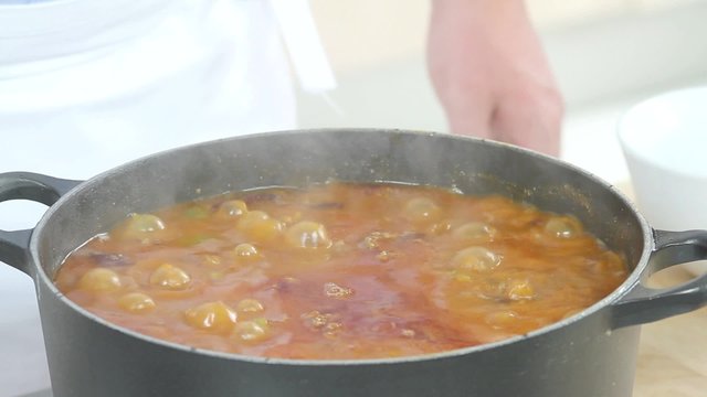 Simmering chilli con carne being seasoned