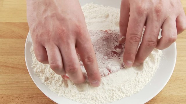 Dredging a veal escalope in flour