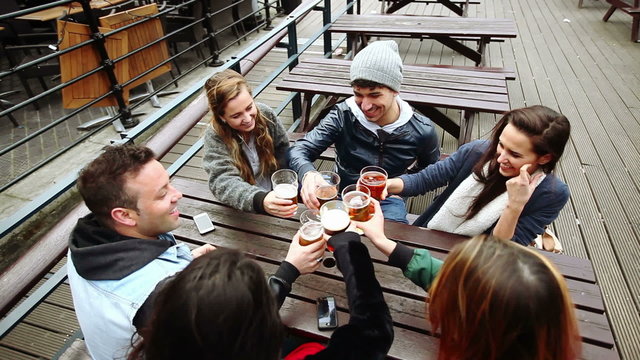Group of friends enjoying a beer at pub in London
