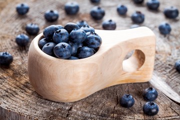 fresh organic blueberries in a wooden mug
