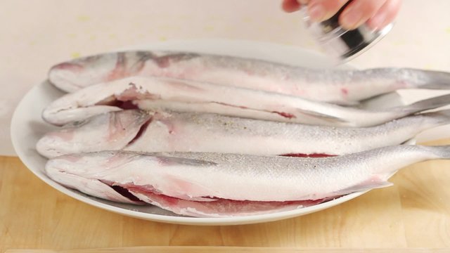 Seasoning a cleaning fish with pepper
