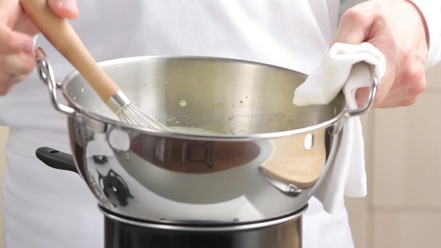Beating cr&egrave;me in bowl over pan of simmering water