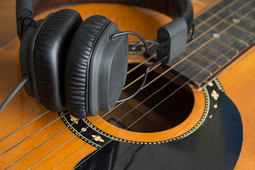headphone and guitar on wood
