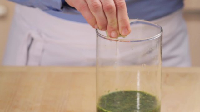 Herb sauce being seasoned with lemon juice and spices