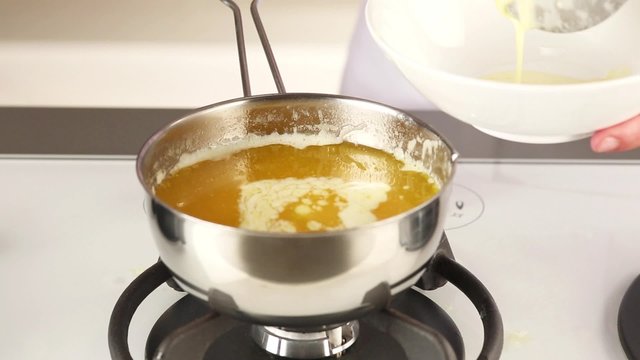 Foam being scooped from melted butter